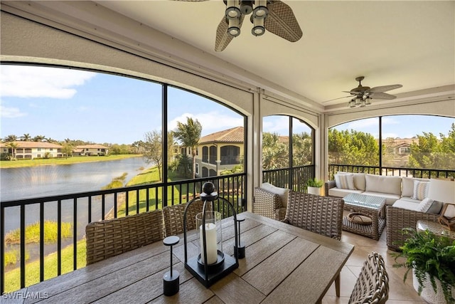 sunroom with a water view and ceiling fan