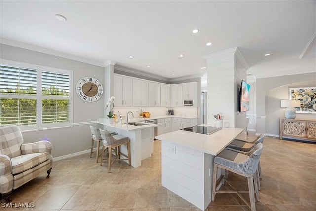 kitchen featuring a peninsula, stainless steel appliances, a kitchen breakfast bar, and crown molding