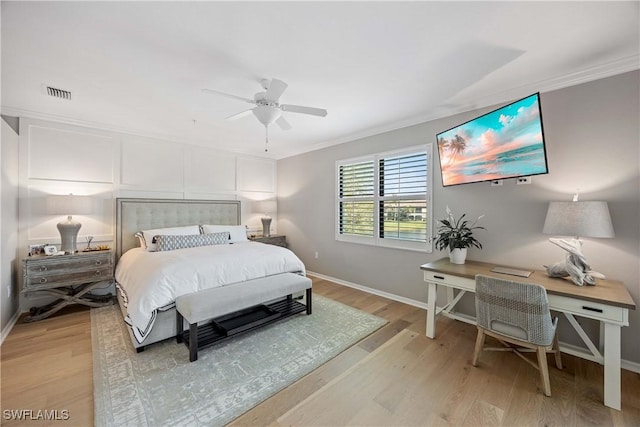 bedroom with ceiling fan, visible vents, baseboards, ornamental molding, and light wood-type flooring