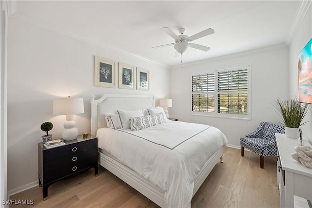 bedroom featuring light wood finished floors, a ceiling fan, baseboards, and crown molding