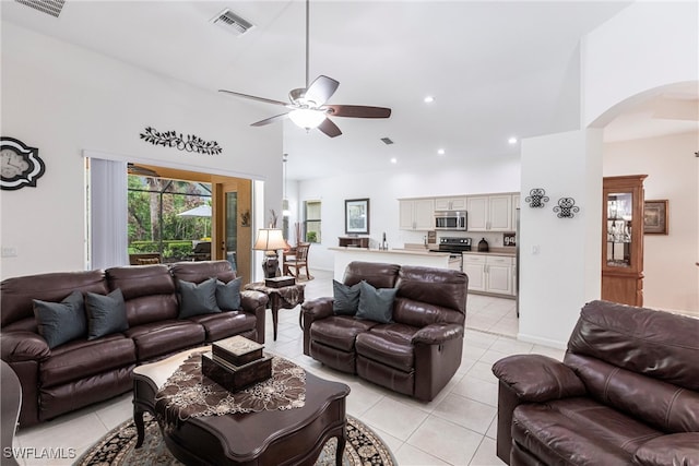 12020 Bramble Cove Dr, Fort Myers, FL 33905 - living room featuring light tile patterned flooring, arched walkways, a towering ceiling, visible vents, and a ceiling fan