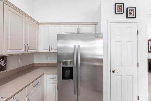 12020 Bramble Cove Dr, Fort Myers, FL 33905 - kitchen featuring white cabinets, light countertops, and stainless steel fridge with ice dispenser