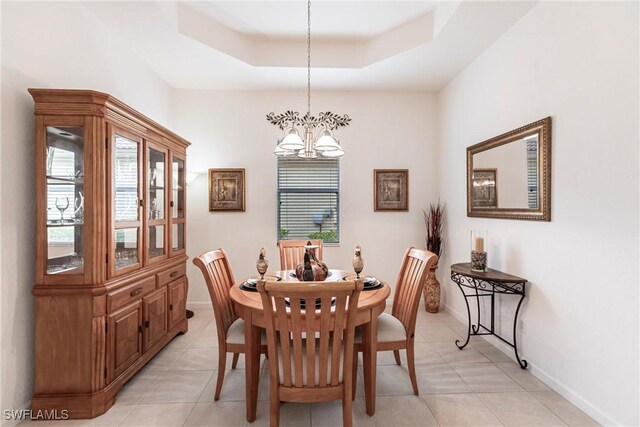 12020 Bramble Cove Dr, Fort Myers, FL 33905 - dining room with light tile patterned flooring, a tray ceiling, baseboards, and a notable chandelier