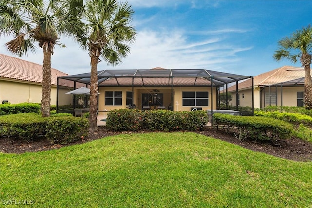 12020 Bramble Cove Dr, Fort Myers, FL 33905 - back of house with glass enclosure, stucco siding, and a yard