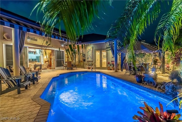 pool with french doors and a patio area