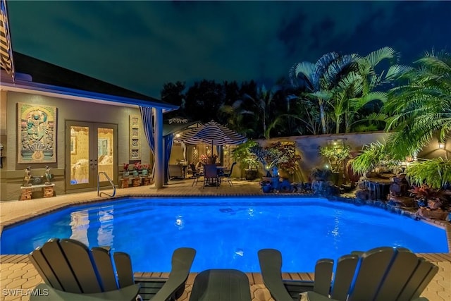 pool at twilight featuring a fenced in pool, french doors, and a patio area