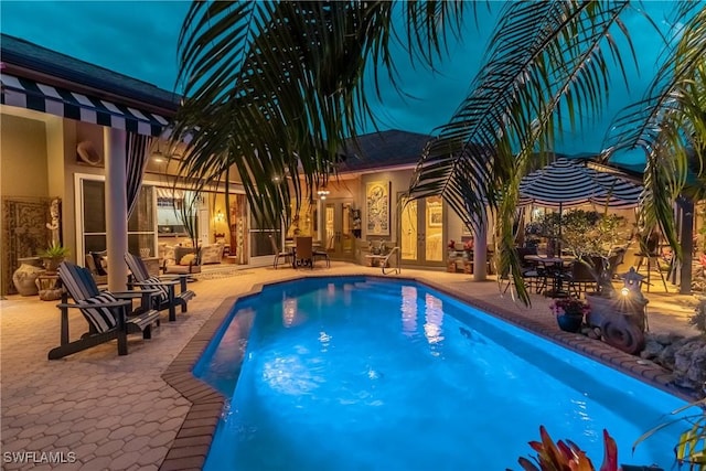 outdoor pool with a patio and french doors