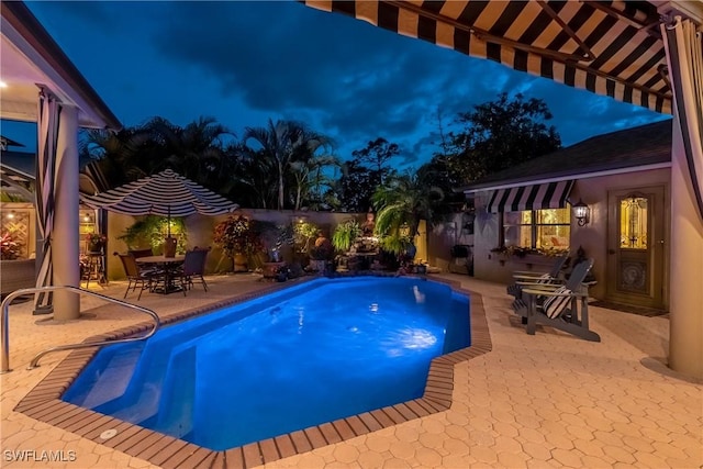 834 Coldstream Ct, Naples, FL 34104 - pool at twilight featuring a patio, a fenced backyard, and outdoor dining space