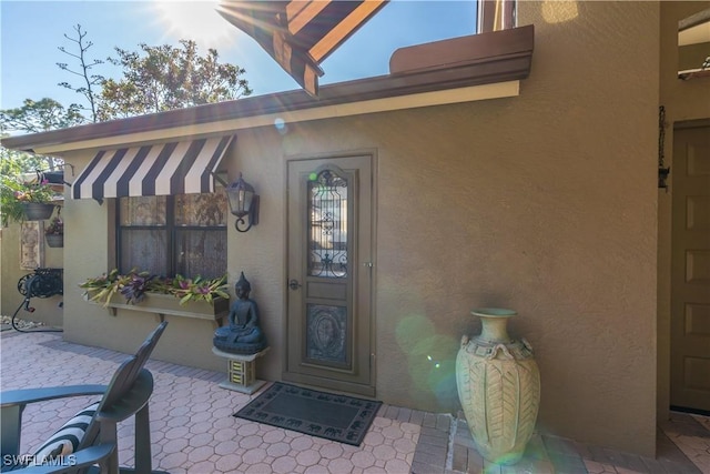 834 Coldstream Ct, Naples, FL 34104 - property entrance with stucco siding and a patio area