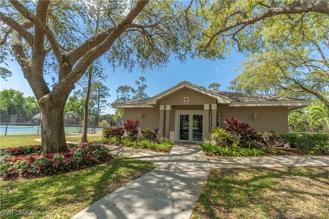 834 Coldstream Ct, Naples, FL 34104 - view of front of home with a tennis court, french doors, and stucco siding