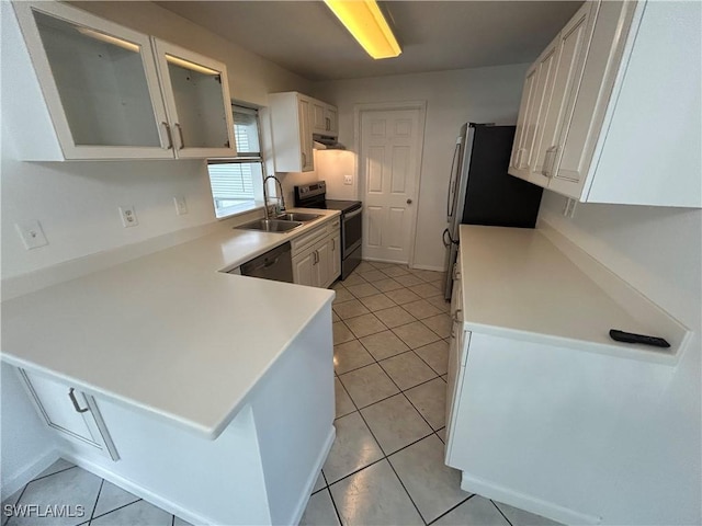 kitchen with light tile patterned floors, light countertops, appliances with stainless steel finishes, white cabinets, and a sink