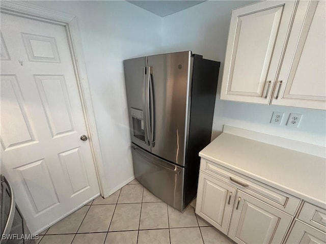 kitchen with light tile patterned floors, stainless steel refrigerator with ice dispenser, and light countertops