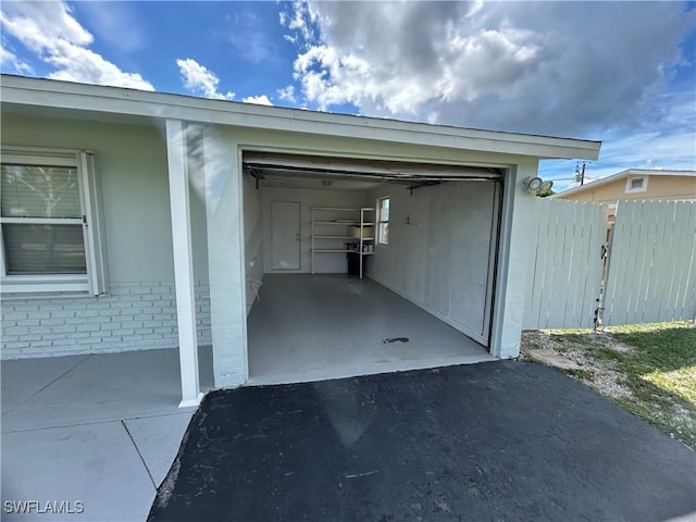 garage with driveway and fence