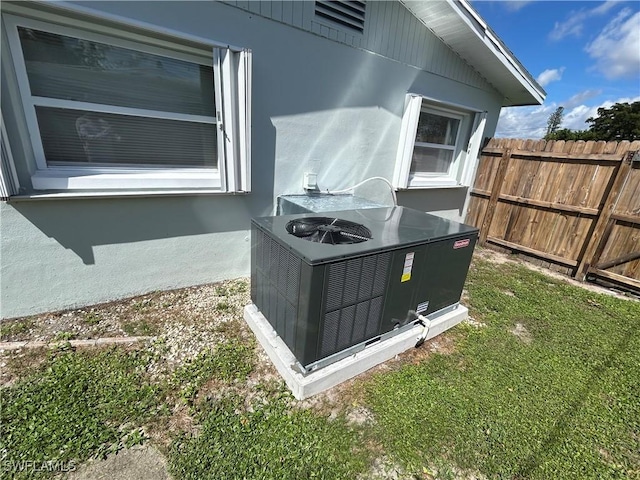 details featuring central AC unit, fence, and stucco siding