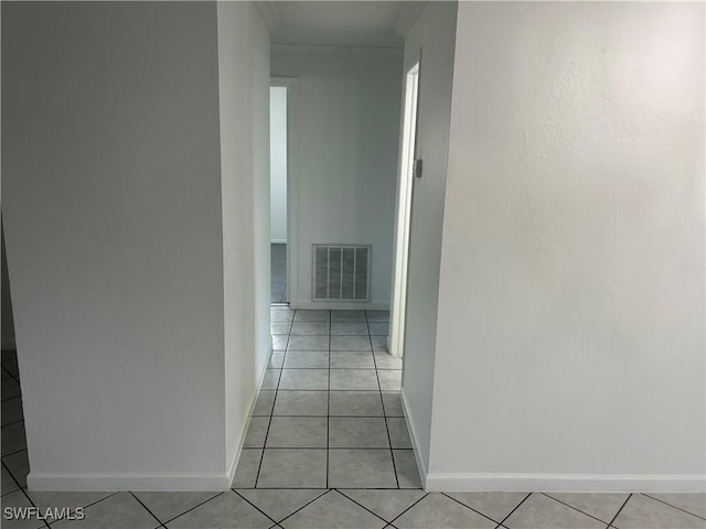 hall featuring visible vents, crown molding, baseboards, and light tile patterned floors