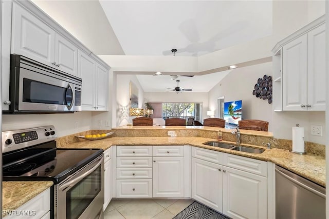 kitchen featuring stainless steel appliances, white cabinetry, a sink, and a peninsula