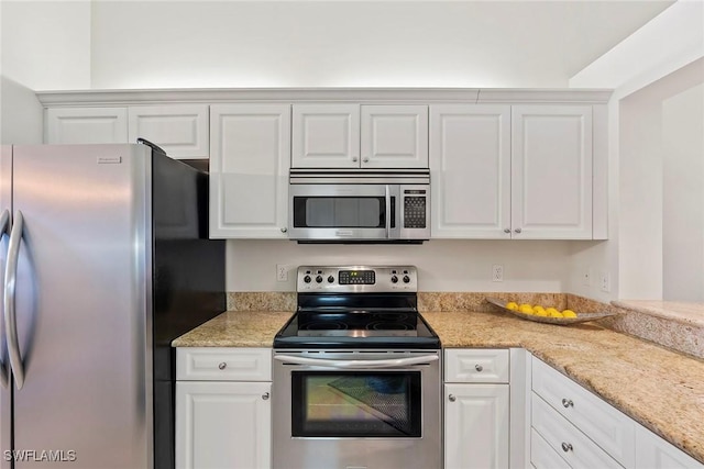 kitchen with appliances with stainless steel finishes, white cabinets, and light stone countertops