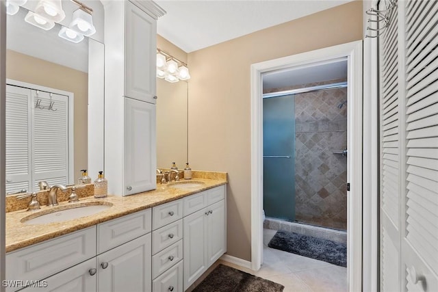 full bath featuring a closet, tile patterned flooring, a sink, and a shower stall