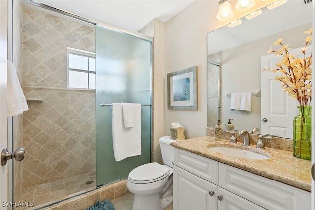 full bathroom featuring a stall shower, tile patterned flooring, vanity, and toilet