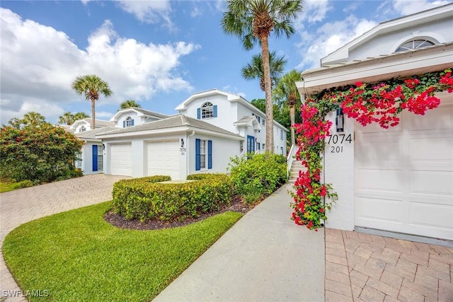 7070 Barrington Cir Unit 202, Naples, FL 34108 - view of front facade with stucco siding, decorative driveway, and an attached garage