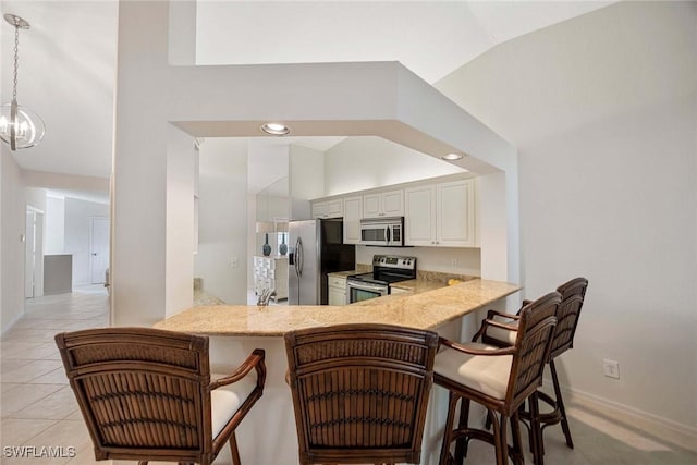 7070 Barrington Cir Unit 202, Naples, FL 34108 - kitchen featuring appliances with stainless steel finishes, a kitchen bar, a peninsula, baseboards, and recessed lighting