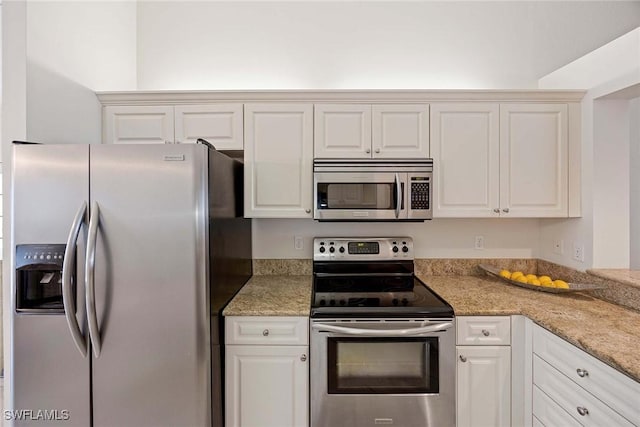 7070 Barrington Cir Unit 202, Naples, FL 34108 - kitchen featuring appliances with stainless steel finishes, light stone countertops, and white cabinets