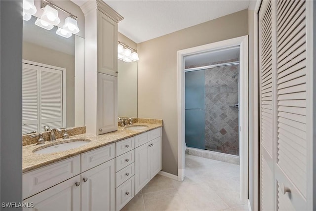 7070 Barrington Cir Unit 202, Naples, FL 34108 - full bathroom with a closet, a shower stall, tile patterned flooring, double vanity, and baseboards