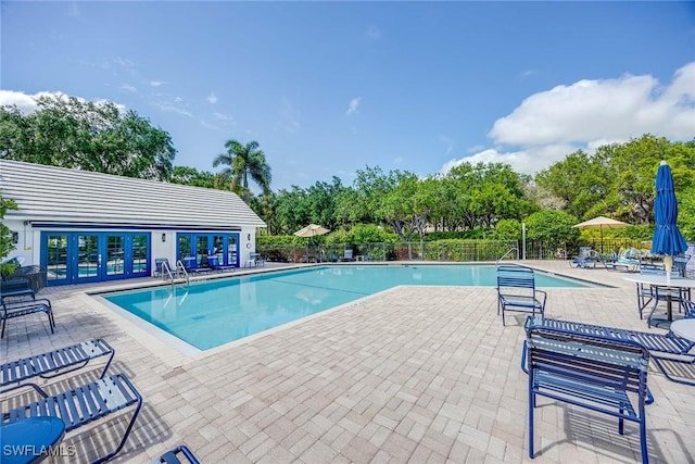 7070 Barrington Cir Unit 202, Naples, FL 34108 - community pool with a patio, french doors, and view of scattered trees