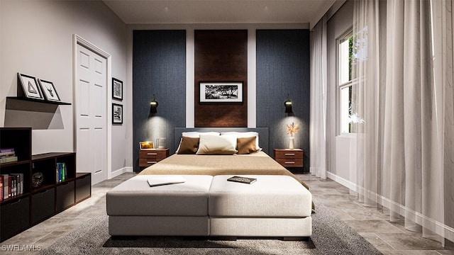 bedroom with stone finish flooring, an accent wall, and baseboards