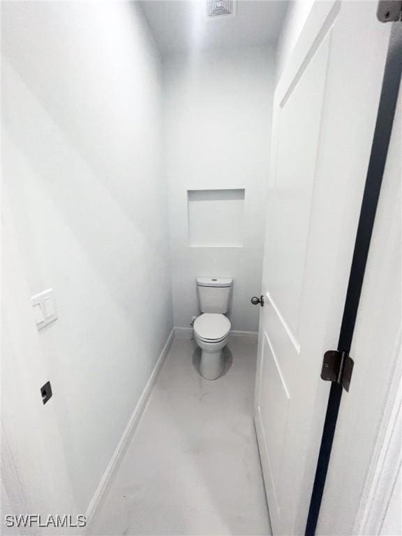 bathroom with toilet and baseboards