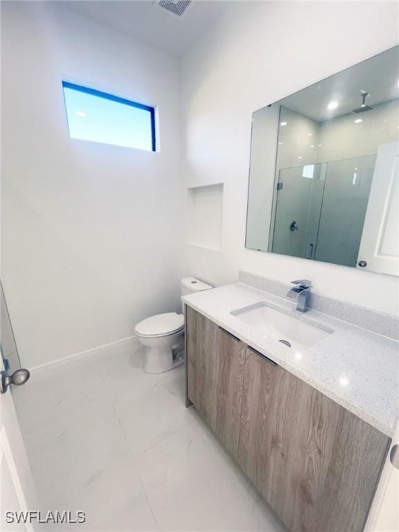 full bath featuring toilet, vanity, baseboards, marble finish floor, and a stall shower