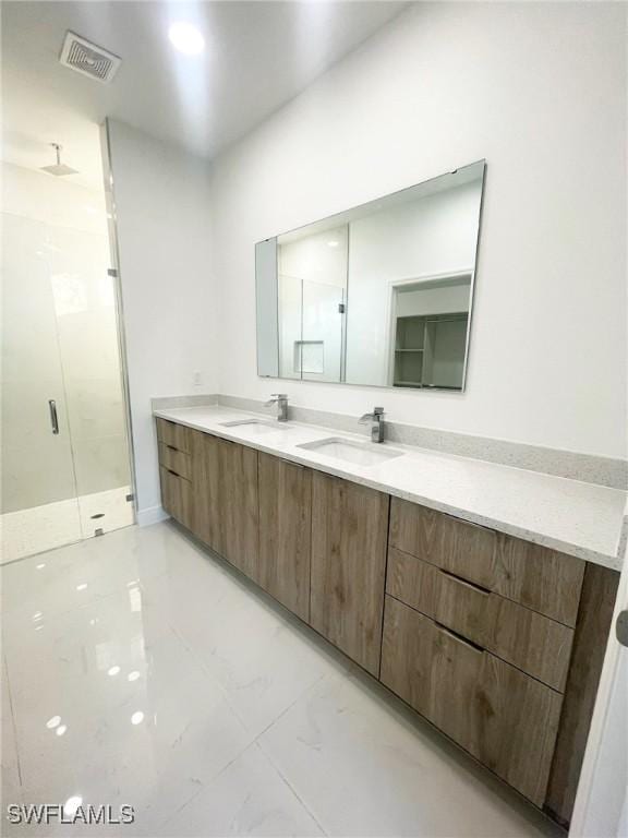 full bath with marble finish floor, visible vents, a sink, and a shower stall