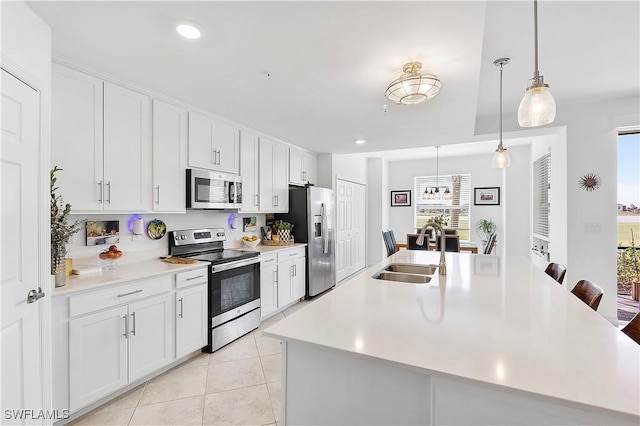 kitchen with light tile patterned floors, appliances with stainless steel finishes, light countertops, and a sink