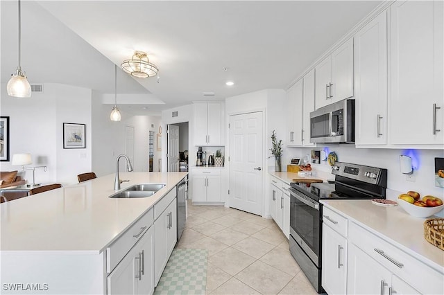 kitchen featuring stainless steel appliances, light countertops, a sink, and white cabinetry