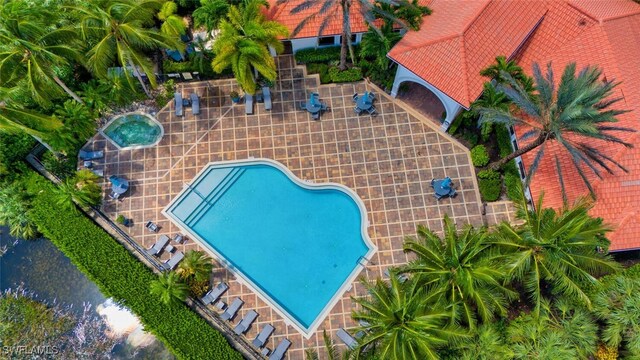 community pool featuring a patio and a hot tub