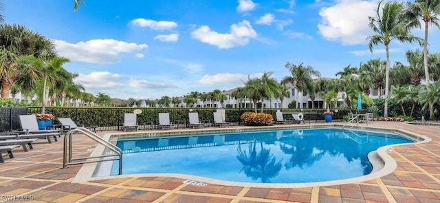 community pool with a patio and fence