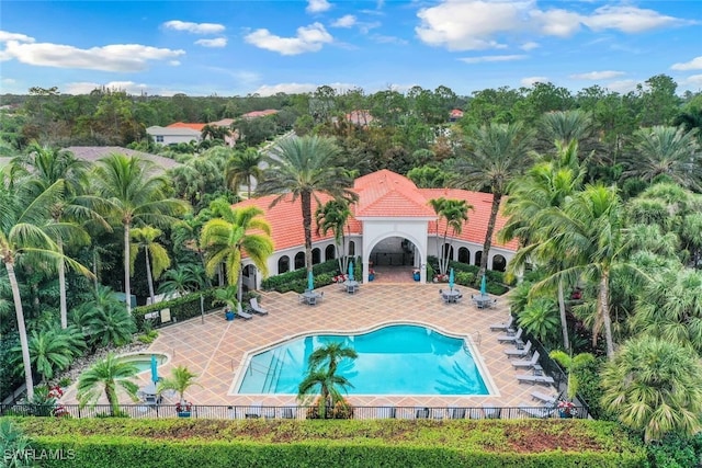 community pool featuring fence and a patio