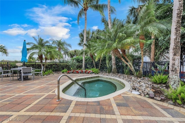 view of swimming pool featuring fence, outdoor dining space, a hot tub, and a patio area
