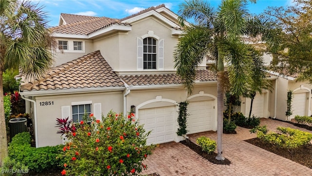 mediterranean / spanish-style home featuring a tiled roof, decorative driveway, and stucco siding