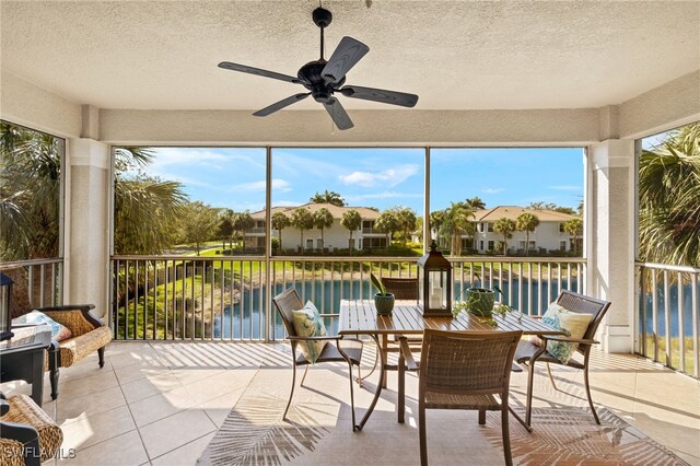 sunroom / solarium featuring a water view, ceiling fan, and a wealth of natural light