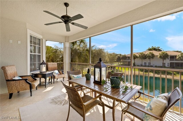 sunroom with a water view and a ceiling fan