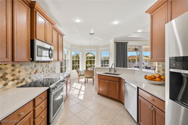 kitchen featuring a peninsula, a sink, visible vents, appliances with stainless steel finishes, and crown molding