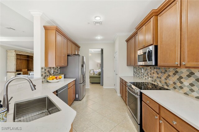 kitchen with visible vents, appliances with stainless steel finishes, light countertops, crown molding, and a sink