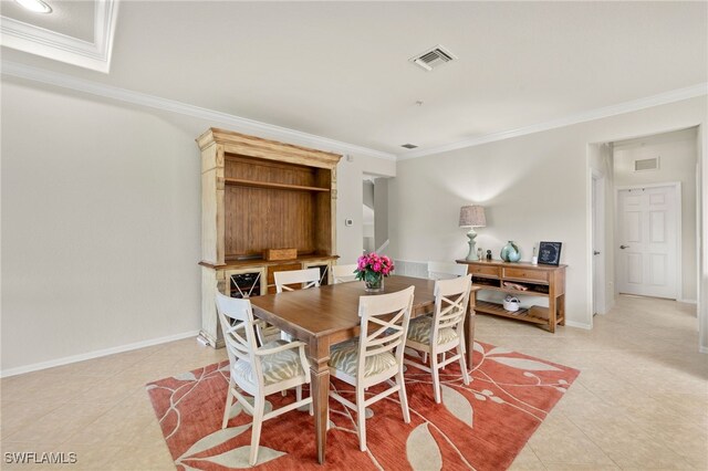 dining space featuring baseboards, visible vents, and crown molding