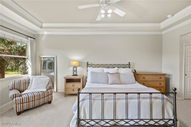 bedroom with crown molding, light colored carpet, and a tray ceiling