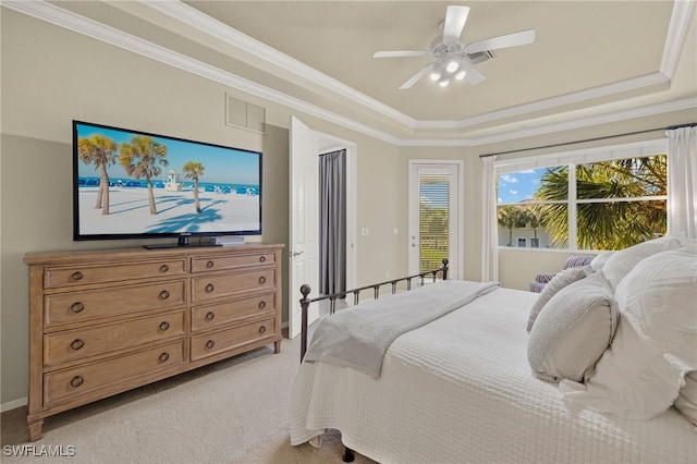 bedroom with ornamental molding, a tray ceiling, visible vents, and light carpet