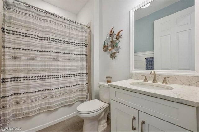 full bath with shower / tub combo with curtain, vanity, toilet, and wood finished floors