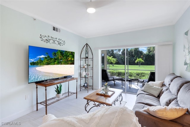 living room featuring baseboards, visible vents, and ornamental molding