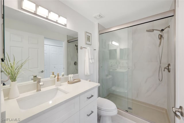 bathroom with visible vents, toilet, vanity, and a marble finish shower