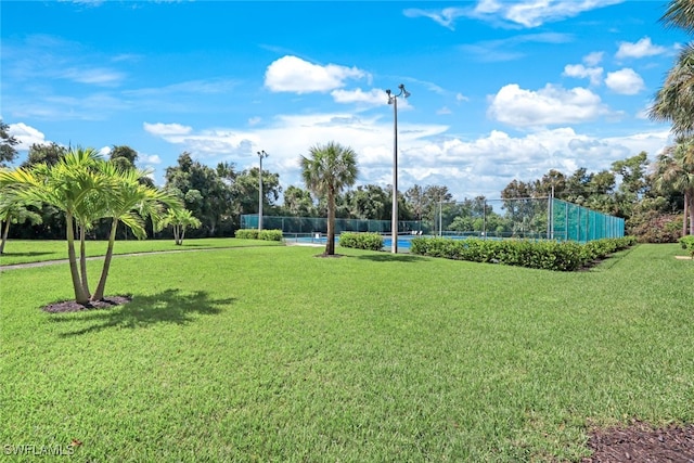 view of home's community featuring a yard and fence